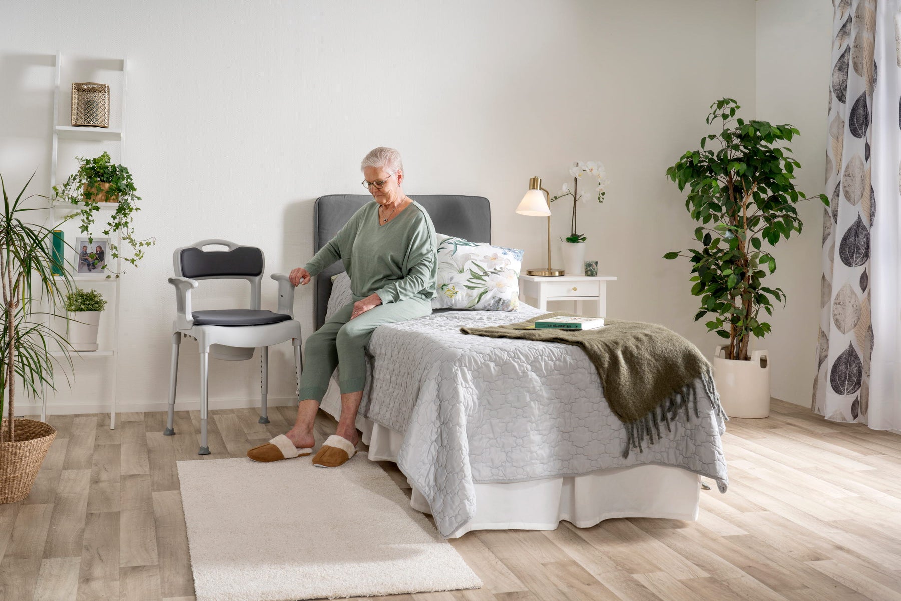 Caregiver helping elder to use potty chair